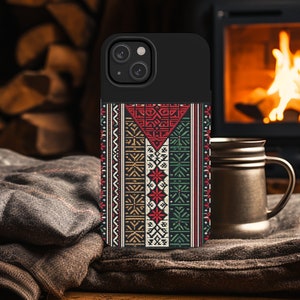 May include: A black phone case with a colorful geometric pattern. The pattern features red, green, white, and brown colors. The case has a raised camera bump and a black border.