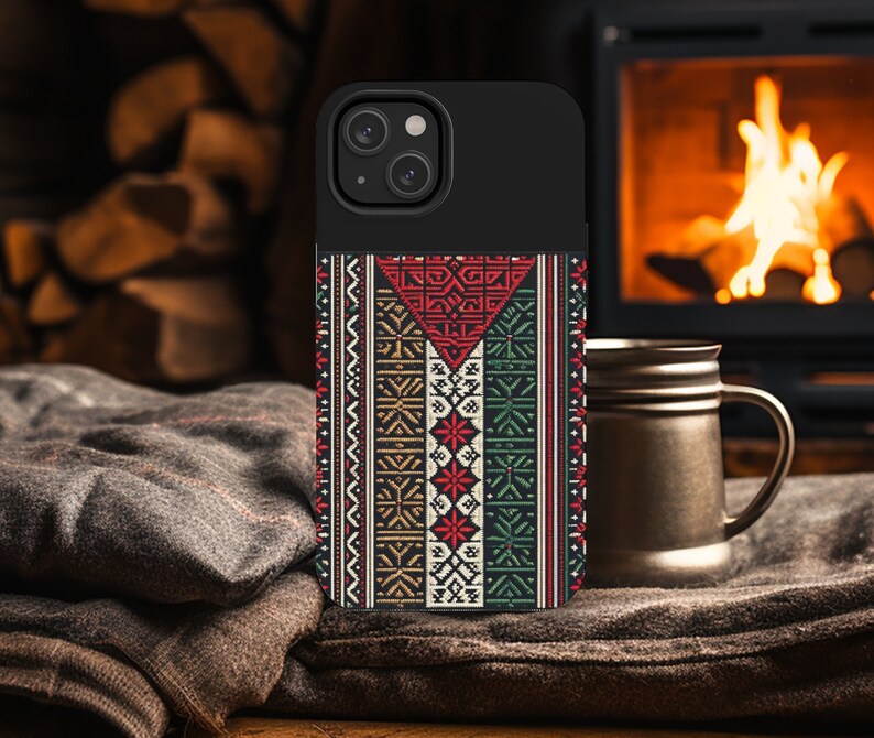 May include: A black phone case with a colorful geometric pattern. The pattern features red, green, white, and brown colors. The case has a raised camera bump and a black border.