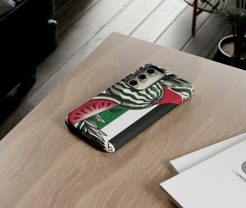 May include: A phone case with a watermelon and green and white striped design. The case has a black border and a camera cutout.