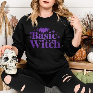May include: A black sweatshirt with a purple graphic that says "Basic Witch" with a bat and stars.