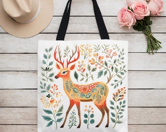 May include: A white tote bag with a colorful illustration of a deer with floral patterns. The deer is standing in a field of flowers and leaves.