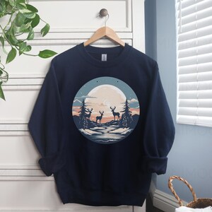 May include: Navy blue sweatshirt with a graphic of three deer standing in a forest scene with a full moon in the background.