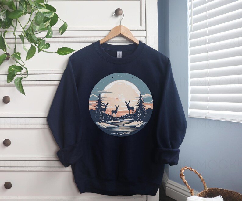 May include: Navy blue sweatshirt with a graphic of three deer standing in a forest scene with a full moon in the background.