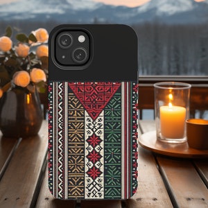 May include: A black phone case with a colorful geometric pattern. The pattern features red, green, white, and gold colors. The case has a cutout for the phone's camera.