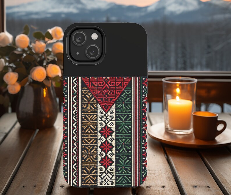 May include: A black phone case with a colorful geometric pattern. The pattern features red, green, white, and gold colors. The case has a cutout for the phone's camera.