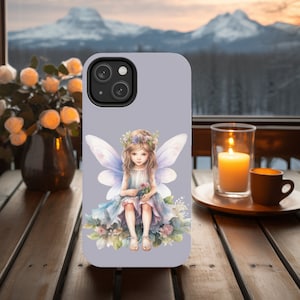 May include: A purple phone case with a fairy illustration. The fairy has wings, a flower crown, and is holding a flower. The background is a soft purple.