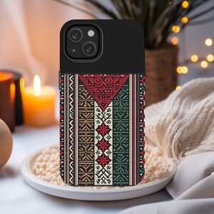 May include: A black phone case with a colorful geometric pattern. The pattern features red, green, white, and black colors. The case has a cutout for the phone's camera.