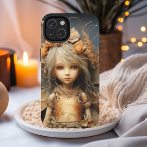 May include: A phone case with a whimsical design featuring a fairy-like figure with delicate wings and floral accents. The figure has long blonde hair, blue eyes, and is wearing a tattered, earthy-toned dress. The case is black and has a camera cutout.