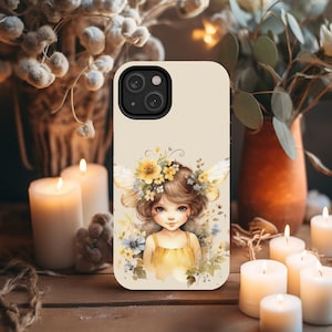 May include: A phone case with a cream background featuring a whimsical illustration of a fairy with brown hair, wearing a yellow dress and a flower crown. The fairy has wings and is surrounded by flowers.