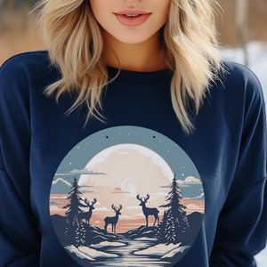May include: A navy blue sweatshirt with a graphic print of a full moon, three deer, and a forest scene. The moon is a pale yellow color with a crescent moon shape in the center. The deer are silhouetted against the moon and forest.