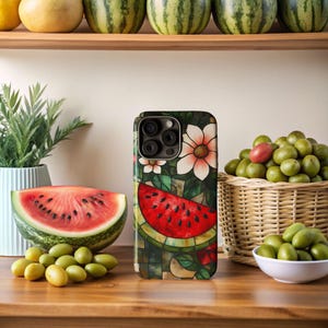 Puede incluir: Una funda para teléfono con un diseño colorido que presenta una rebanada de sandía, flores y una lente de cámara. La funda está hecha de un material plástico duro y tiene un acabado brillante.