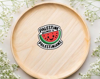 May include: A sticker with a cartoon watermelon with a smiling face. The text on the sticker reads "Palestine belongs to Palestinians".
