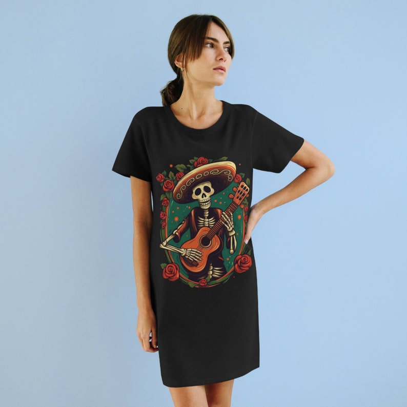May include: Black t-shirt dress with a colorful illustration of a skeleton playing a guitar and wearing a sombrero. The skeleton is surrounded by red roses.