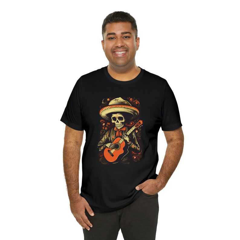 May include: Black t-shirt with a graphic of a skeleton wearing a sombrero and playing a guitar.