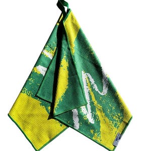 May include: A green and yellow microfiber towel with a white abstract design. The towel is folded and has a hanging loop.