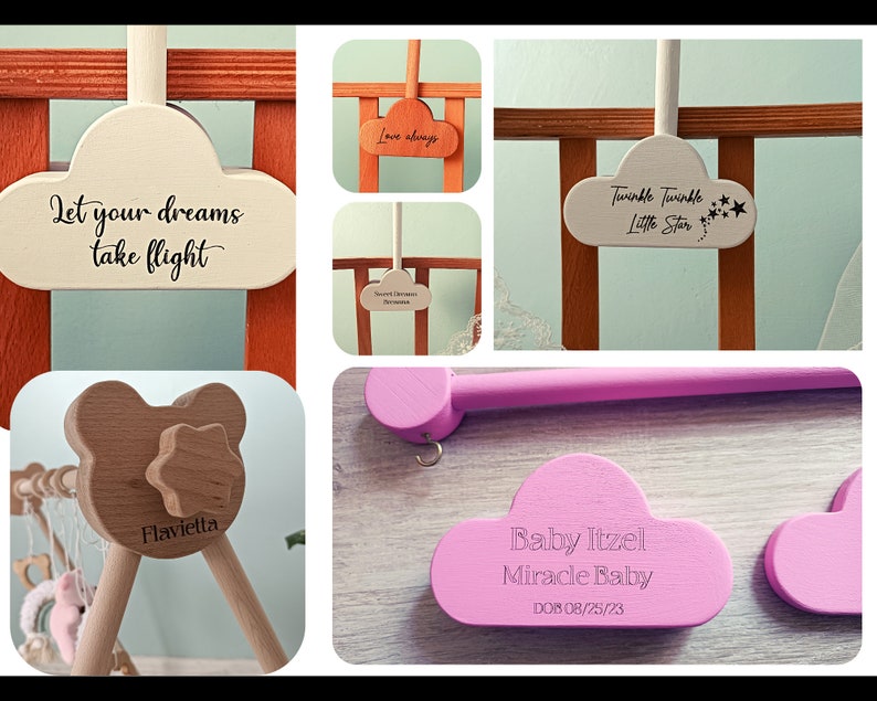May include: A set of wooden baby mobile parts with cloud-shaped pieces that can be personalized with text. The clouds are painted in white, pink, and light brown. The text on the clouds includes "Let your dreams take flight", "Love always", "Twinkle Twinkle Little Star", "Baby Itzel Miracle Baby DOB 08/25/23", and "Flavietta".