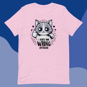 Puede incluir: Camiseta rosa con un gato de dibujos animados dando un pulgar hacia arriba en cada mano. El texto dice "Respeto tu opinión equivocada".