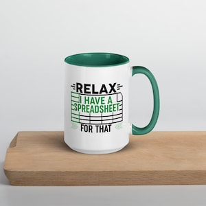 Könnte beinhalten: Weiße Keramiktasse mit grünem Rand und Henkel. Die Tasse hat eine schwarze Grafik mit der Aufschrift "Relax I have a spreadsheet for that" mit einem grünen Tabellenkalkulationssymbol.
