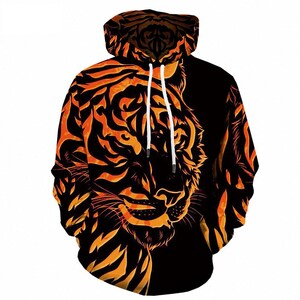 May include: Black hoodie with a vibrant orange tiger face design. The tiger's face and stripes are prominently displayed across the front and hood. The hoodie features a drawstring and a comfortable, casual style.