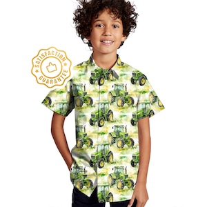 May include: A white short-sleeved button-down shirt with a green and yellow watercolour print of tractors. The shirt has a collar and a pocket on the left side.