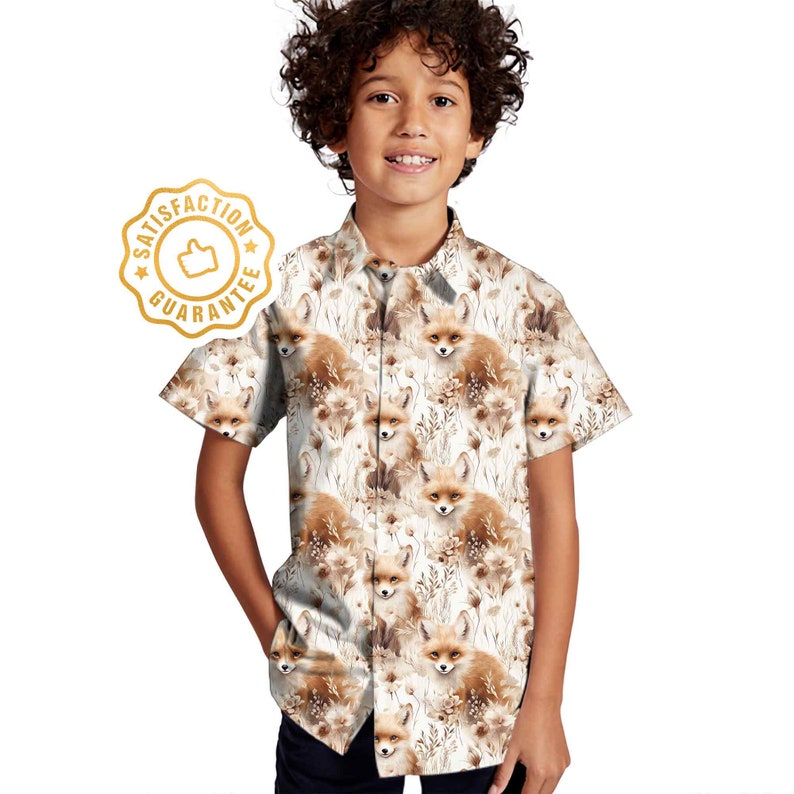 May include: A white short-sleeved button-down shirt with a fox print. The shirt has a brown and white fox pattern with a white background. The shirt has a collar and a button closure.