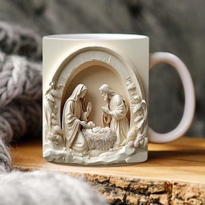 Może przedstawiać: Kremowy ceramiczny kubek z trójwymiarowym reliefem przedstawiającym scenę Bożego Narodzenia. Projekt obejmuje Maryję, Józefa i małego Jezusa w żłóbku, umieszczonych w łukowatej strukturze. Kubek ma zakrzywiony uchwyt i stoi na drewnianej powierzchni.