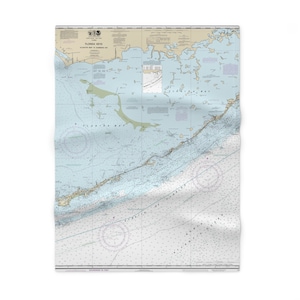 May include: A nautical chart of the Florida Keys, showing the coastline and surrounding waters. The chart is printed on a white background with blue and green lines and text. The chart includes a compass rose, depth soundings, and navigational aids.