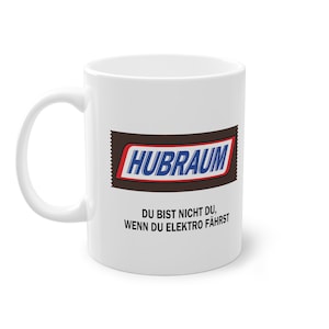 Könnte beinhalten: Weiße Keramiktasse mit einer braunen und blauen Grafik einer Schokoladentafel mit dem Text "Hubraum" und dem Text "Du bist nicht du, wenn du Elektro fährst".