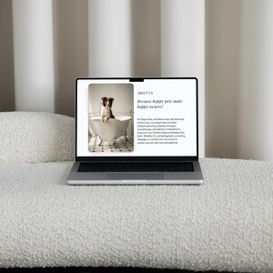 May include: A laptop computer displaying a website for a pet grooming service. The website features a photo of a dog in a bathtub and the text "Because happy pets make happy owners!"