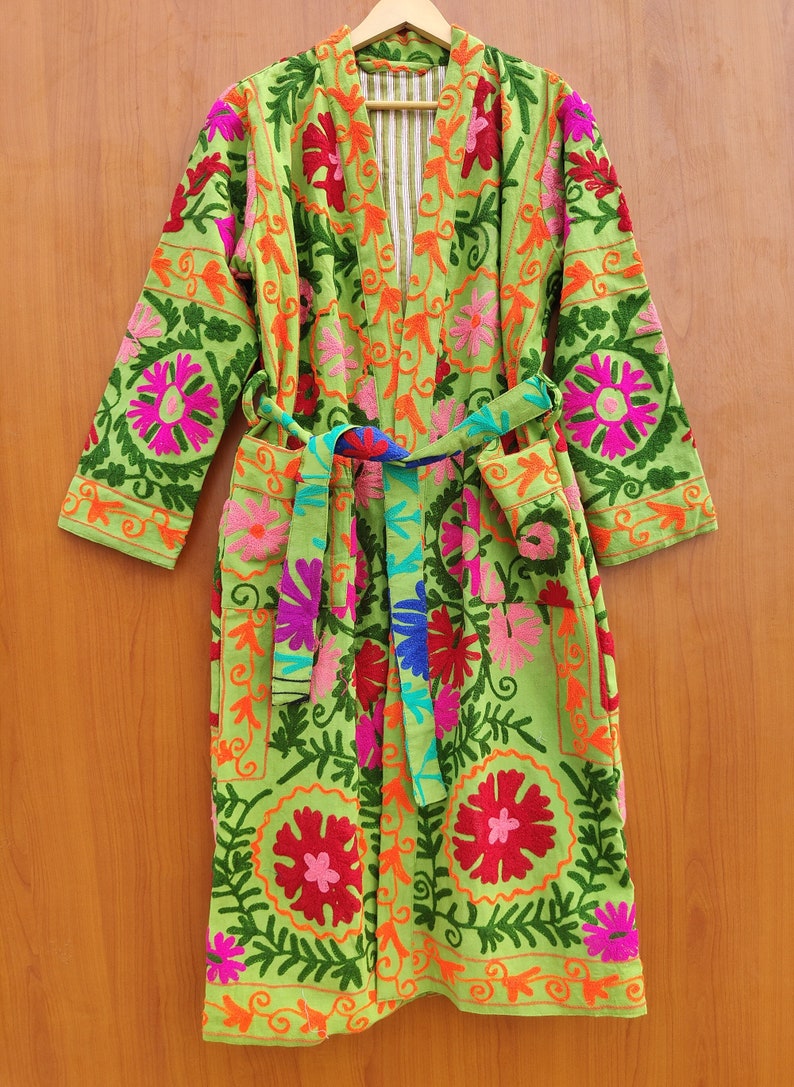May include: A green robe with colourful floral embroidery. The robe has a tie belt and long sleeves.