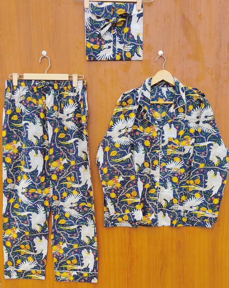 May include: A blue pajama set with a white bird and lemon print. The set includes a long-sleeved shirt and pants.
