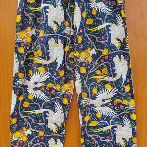 May include: Blue pajama pants with a white cockatoo and yellow fruit print.