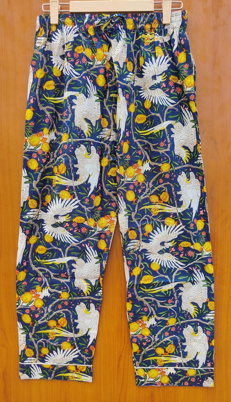 May include: Blue pajama pants with a white cockatoo and yellow fruit print.