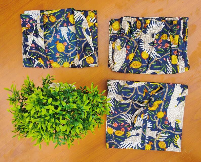 May include: A set of four blue and white patterned pajama tops with a tropical bird design. The fabric has a white background with blue leaves and white birds.