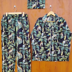 May include: A black pajama set with a green and white jungle print featuring leopards. The set includes a long-sleeved shirt and pants.