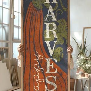 Close crop of the orange pumpkin and cream harvest letters on the deep navy ground.
