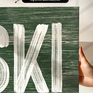 a person holding up a sign that says ski
