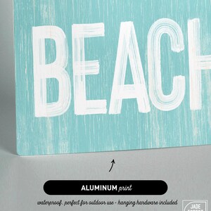A close-up of the Meet Me At The Beach sign's lettering reading Beach, labeled as the aluminum print option.