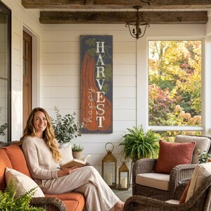 Harvest panel in navy and orange behind a woman seated in a rattan porch chair.