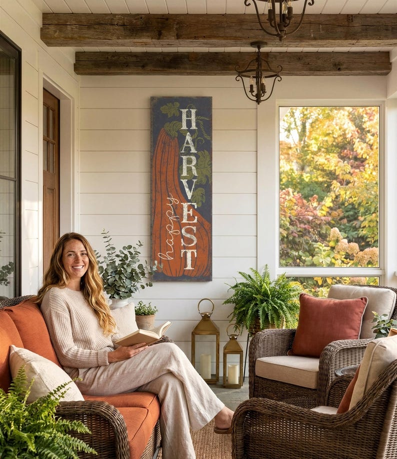 Harvest panel in navy and orange behind a woman seated in a rattan porch chair.