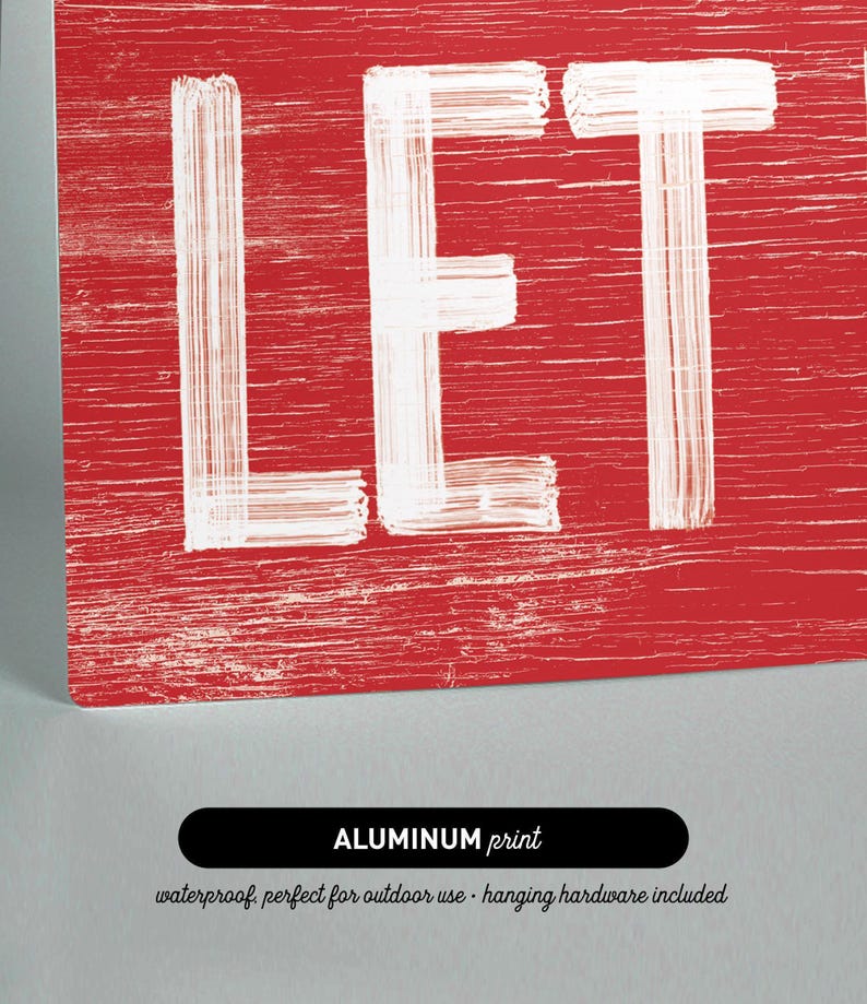 Close up of the "Let It Snow" sign printed on aluminum, showing the barn red background and crisp white lettering.