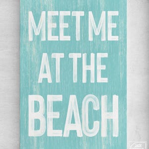 A full view of the teal Meet Me At The Beach sign's complete lettering.
