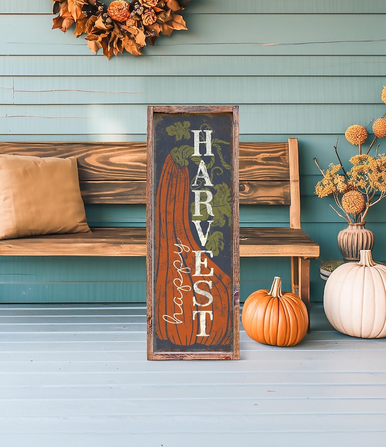 Navy harvest panel with an orange pumpkin propped on teal porch boards beside a wood bench.