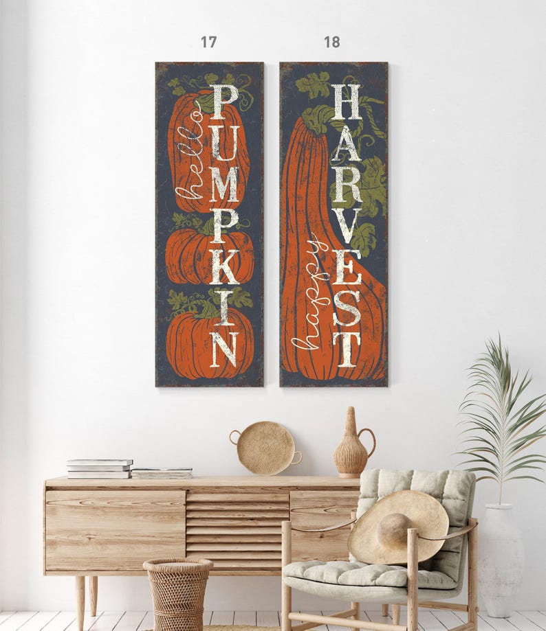 Two tall panels reading pumpkin and harvest hung side by side above a light wood console.