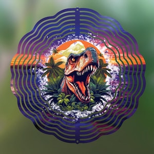 Op de afbeelding: Een decoratieve metalen windspinner met een T-Rex dinosaurusontwerp. Het kunstwerk bevat een zonsondergang, palmbomen en een berg. De buitenrand heeft een golvend, gelaagd patroon in tinten paars en blauw.