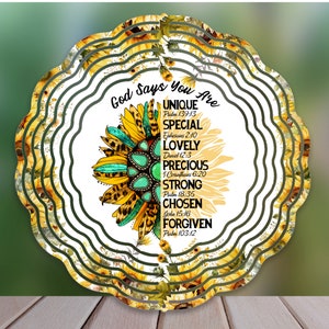 Puede incluir: Un molinete de viento circular blanco con un diseño de girasol. El girasol tiene un centro turquesa y estampado de leopardo. El texto "God Says You Are" está escrito en negro en la parte superior del molinete. El texto va seguido de una lista de palabras y versículos bíblicos, que incluyen "Unique", "Special", "Lovely", "Precious", "Strong", "Chosen" y "Forgiven".