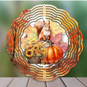 May include: A metal wind spinner with a fall theme. The design features a squirrel, pumpkins, sunflowers, and fall leaves in shades of orange, yellow, and brown.