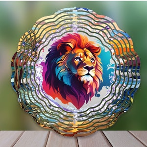 May include: A colorful metal wind spinner with a lion's head in the center. The lion is depicted in a vibrant, abstract style with shades of red, orange, yellow, blue, and purple. The wind spinner has multiple layers of metal that spin in the wind, creating a mesmerizing visual effect.