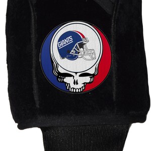May include: Black golf club head cover with a red, white, and blue Grateful Dead-style skull and crossbones design. The skull has a New York Giants football helmet inside with the word "Giants" on the helmet.