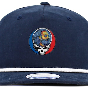 May include: A navy blue baseball cap with a white rope trim around the brim. The cap features a colorful embroidered patch of a skull with a face inside.